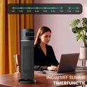 Zwarte AirKing staande kachel met display, naast een vrouw die aan een laptop werkt.