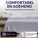 Een comfortabel en ademend grijs dekbed op een opgemaakt bed, verbetert de koeling.