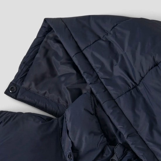 Donkerblauwe gewatteerde jas, detail van de capuchon met drukknoopsluiting.