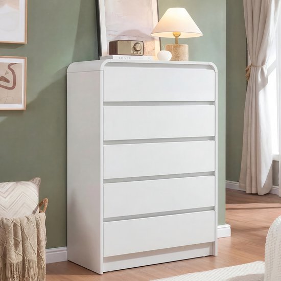 Witte commode met 5 lades in een slaapkamer, met decoratie op de bovenkant.