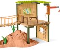 Speelstation met schuine brug, ladder en hijsinstallatie in groen en beige, met houten accenten.