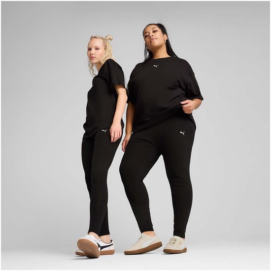 Twee vrouwen, één in zwarte PUMA legging, de ander in zwarte PUMA broek, staand.