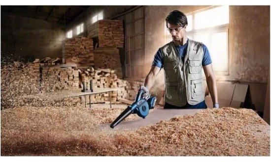 Man in beige vest blaast houtstof weg met blauwe Bosch bladblazer in een werkplaats.