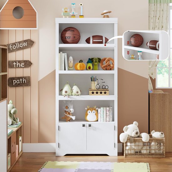 Witte boekenkast in een kinderkamer, gevuld met speelgoed en boeken. Inclusief een basketbal en American football.