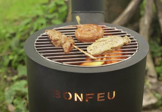Zwart BonFeu tuinhaard met grill, met daarop een worst en satéspiesjes.