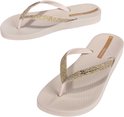 Paar beige Ipanema teenslippers met glitterbandjes op zwarte achtergrond.
