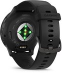 Achterkant van een zwarte smartwatch met hartslagsensor en oplaadpunten.