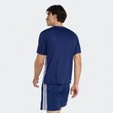 Man doet een oefening met een bal op de schouder, draagt donkerblauw sport T-shirt en korte broek.
