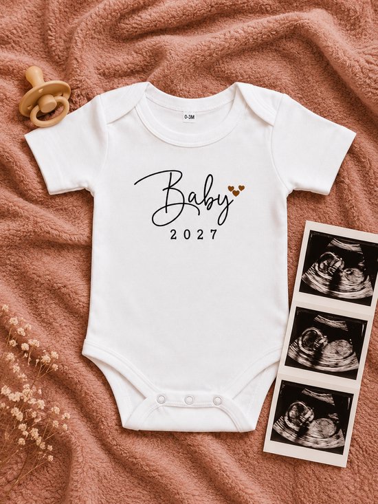 Wit baby rompertje met de tekst 'Baby 2027' en hartjes. Met speen en echo's ernaast.
