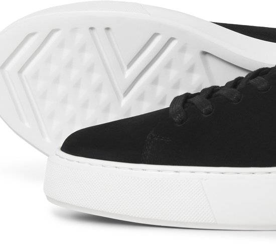Close-up van de zool en zijkant van een zwarte suède sneaker met witte zool.