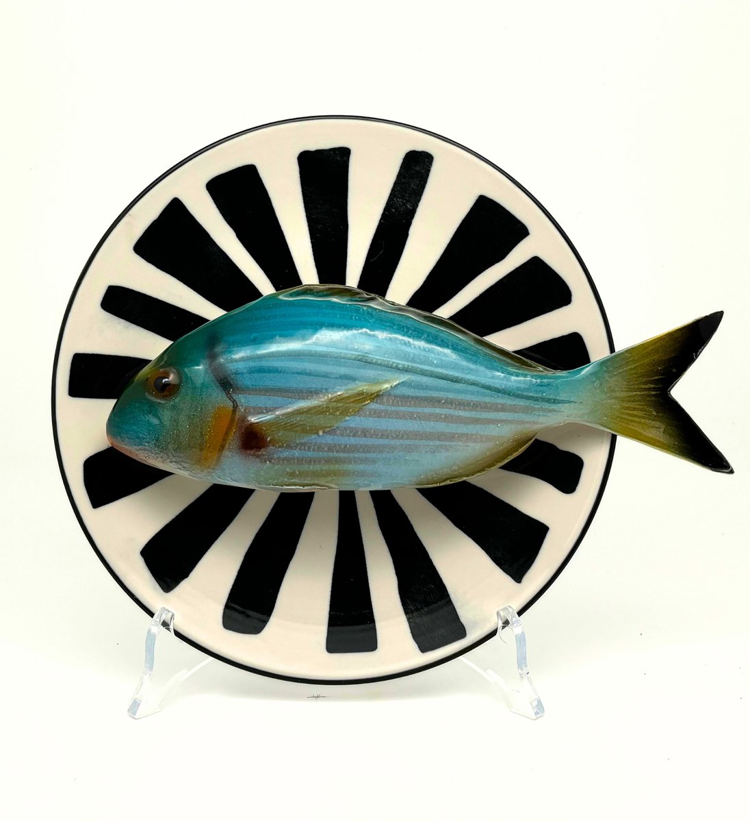 Orata op een wit bord met zwarte decoratieve strepen, 20cm.