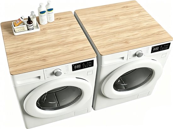Twee wasmachines naast elkaar met een licht houten top beschermer, met zeep en flesjes.