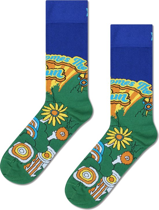 Blauwe sokken met een groene weide, bloemen en de tekst 'Here Comes The Sun' in gele golvende letters.