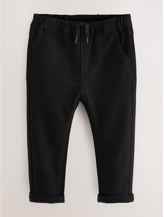 Zwarte broek met elastische tailleband, koordje en opgerolde zoom. Een coin pocket is zichtbaar.