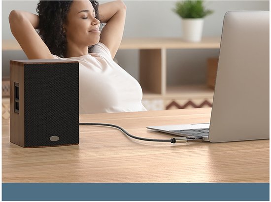 Vrouw ontspant met ogen gesloten terwijl muziek vanaf laptop door een houten speaker speelt.