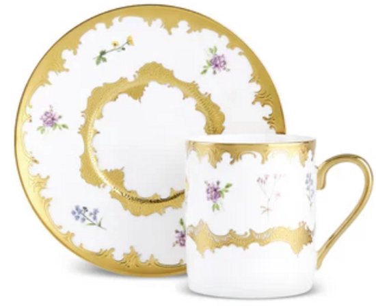 Wit porseleinen koffiekopje en schotel met verfijnd bloemendesign en gouden afwerking, geïsoleerd op wit.