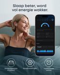 Vrolijke vrouw met witte oordopjes, naast een smartphone met slaapstatistieken en app-icoontjes: slaapregistratie, instellingen, wekker.