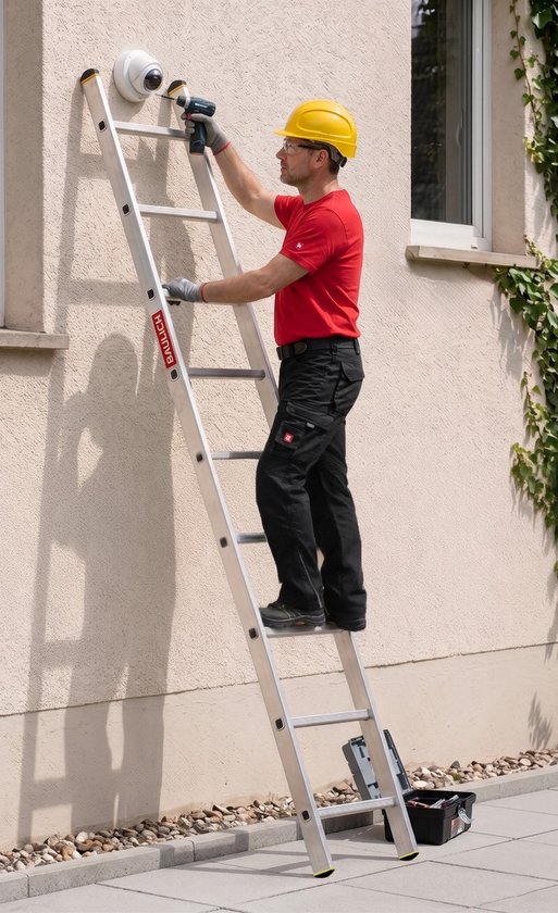 Man met gele helm en rode shirt monteert beveiligingscamera met boormachine op aluminium ladder.