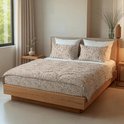 Bed opgemaakt met dekbed en kussenslopen in zandkleurige panterprint.