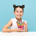 Meisje houdt een vlinder vast, gemaakt van Connetix magnetische tegels in regenboogkleuren.