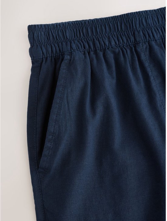 Detail van de elastische tailleband en steekzak van de donkerblauwe linnenmix broek.