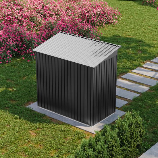 Gesloten zwarte metalen tuinschuur in een tuin met bloemen en gras.