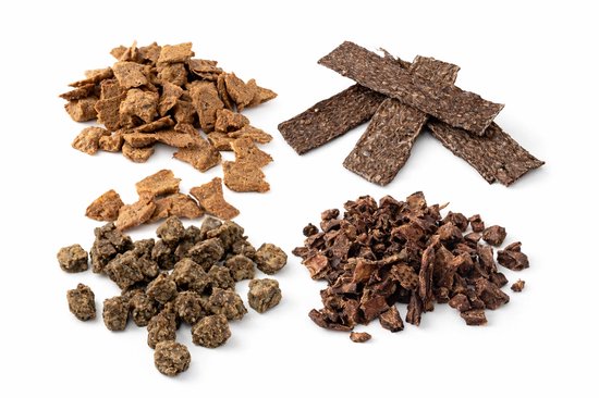 Vier verschillende soorten hondensnacks uitgestald op een witte achtergrond.
