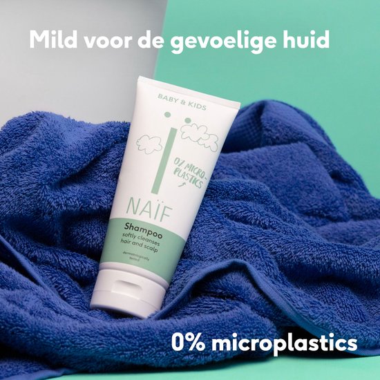 Witte fles Naïf shampoo op een blauwe handdoek. Tekst: "Mild voor de gevoelige huid" en "0% microplastics".