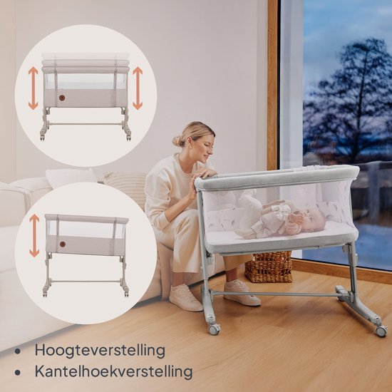 Vrouw met baby in beige co-sleeper naast een raam. Illustreert hoogte- en kantelverstelling.