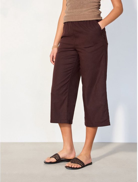 Model draagt bruine culottebroek met steekzakken en een bruin tanktop.