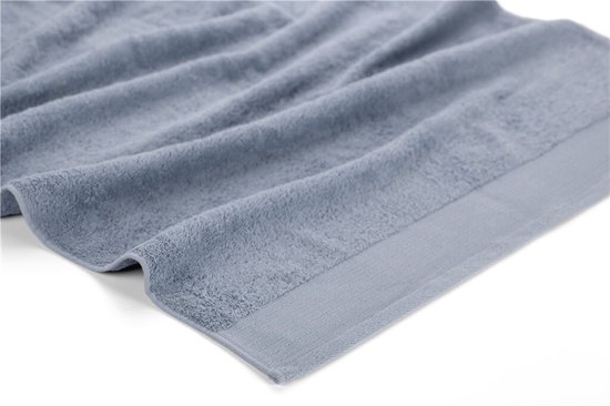 Gedetailleerde opname van een lichtblauwe handdoek, deels gevouwen, met een effen boord.