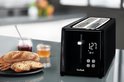 Grille-pain Tefal noir avec écran numérique, à côté d'une assiette avec deux tranches de pain et des épis de blé.