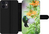 Bookcase Geschikt voor iPhone 12 telefoonhoesje - Close-up van een kleurrijke vogel naast planten met oranje bloemen - Met vakjes - Wallet case met magneetsluiting