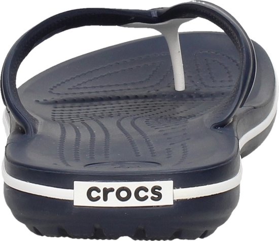 Donkerblauwe Crocs flipflop met witte strepen op de zoolrand. Op de zool staat 'crocs' in witte letters.