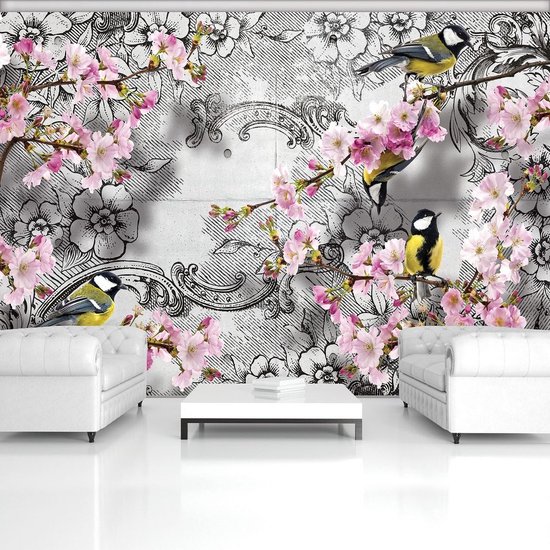 Papier peint avec des fleurs de cerisier rose pâle et des mésanges sur des branches, sur fond de motifs gris et de fleurs.