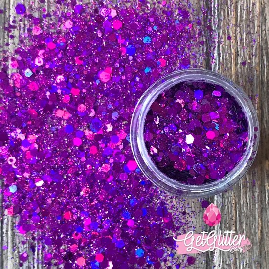 Paarse chunky festival glitters met roze en blauwe accenten, deels in een potje.