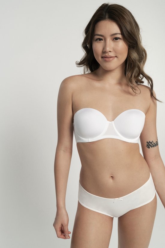 Model met een witte strapless BH en bijpassende slip. De BH heeft een beugel en een strikje aan de voorkant.