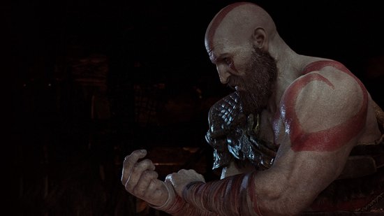 Close-up van Kratos' gezicht met baard, met rode markeringen op zijn armen.