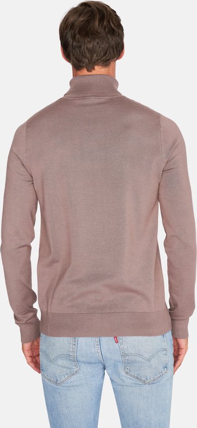 Achterkant van een man met lichte huid, die een taupe coltrui en lichtblauwe jeans draagt.