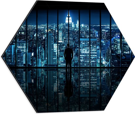 Dibond Hexagon - Man voor Glazen Wand met Uitzicht op de Stad in de Avond - 50x43.5 cm Foto op Hexagon (Met Ophangsysteem)