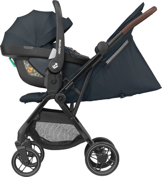 Donkerblauwe Maxi-Cosi kinderwagen met bruine handvatten, met een Maxi-Cosi baby autostoeltje erop.