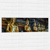 Muursticker - Rijen Gouden Boeddha's in Wat Tham Khuha Sawan Tempel in Thailand - 90x30 cm Foto op Muursticker