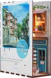Boekensteun 'Island of Love' met café-gevel en stadsafbeelding op de voorgrond.