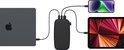 Donkergrijze powerbank laadt een laptop, smartphone en tablet op. Tekst 'TRIPLE POWER'.