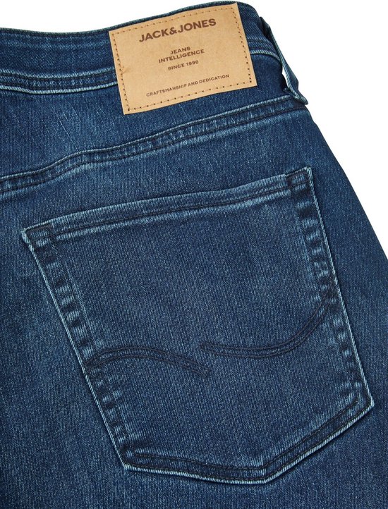 Detail van de achterkant van een blauwe Jack & Jones spijkerbroek met een leren label, zakken en stitching.