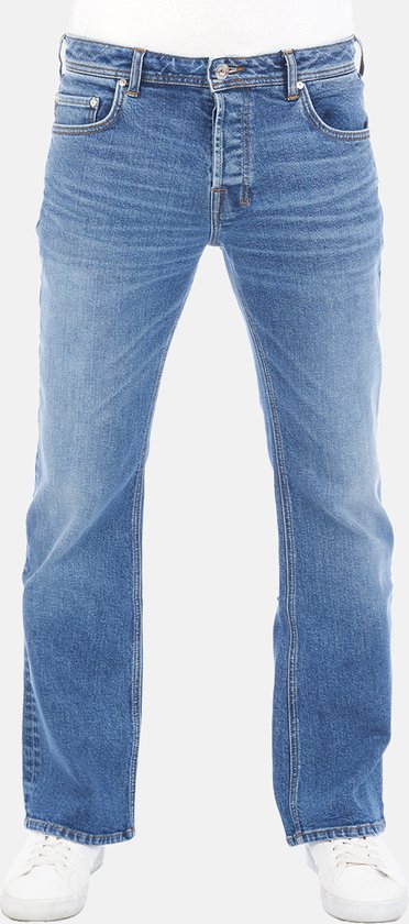 Man in een bootcut blauwe spijkerbroek met witte sneakers, gedetailleerd met knopen en een bruin LTB label.