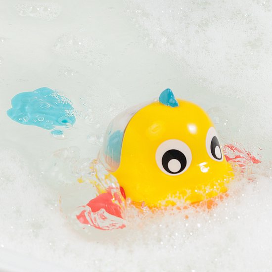 Gele badeend visje met rode vinnen en blauwe staart drijvend in bubbelend water.
