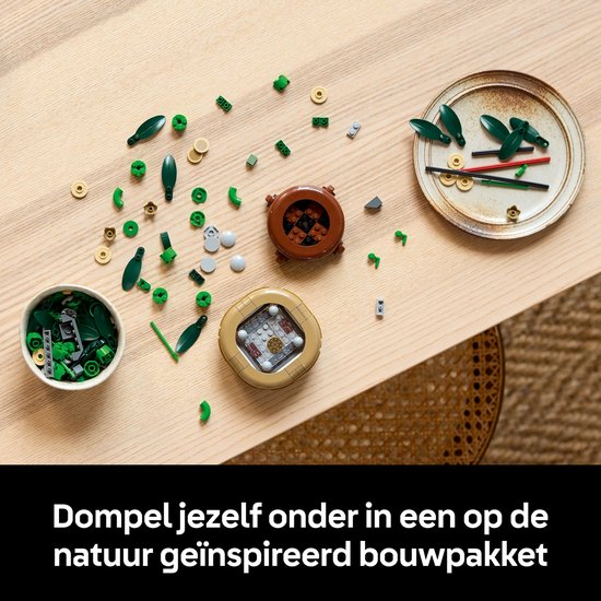 Table en bois avec des pièces LEGO de bambou détachées, des feuilles vertes et des pots.