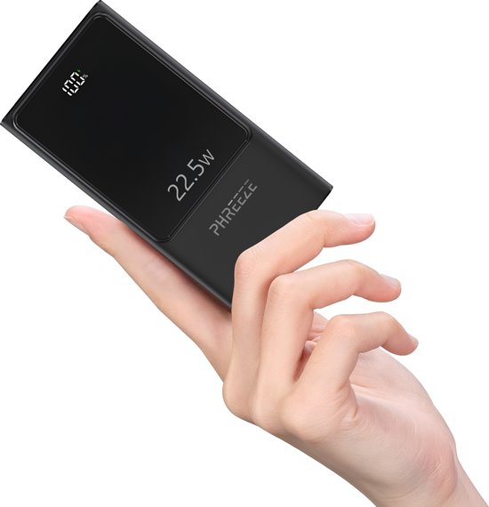 Main féminine tenant une batterie externe noire 22.5W avec 100% de charge.