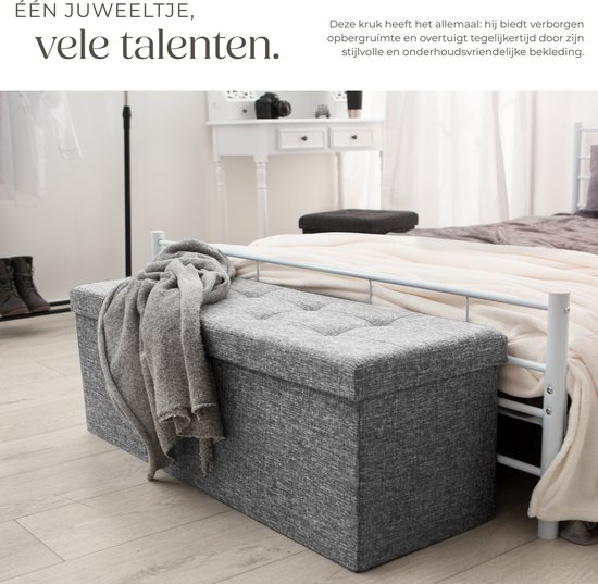 Grijze opbergkist met knopen op een bed. Grijze opbergkist met knopen.